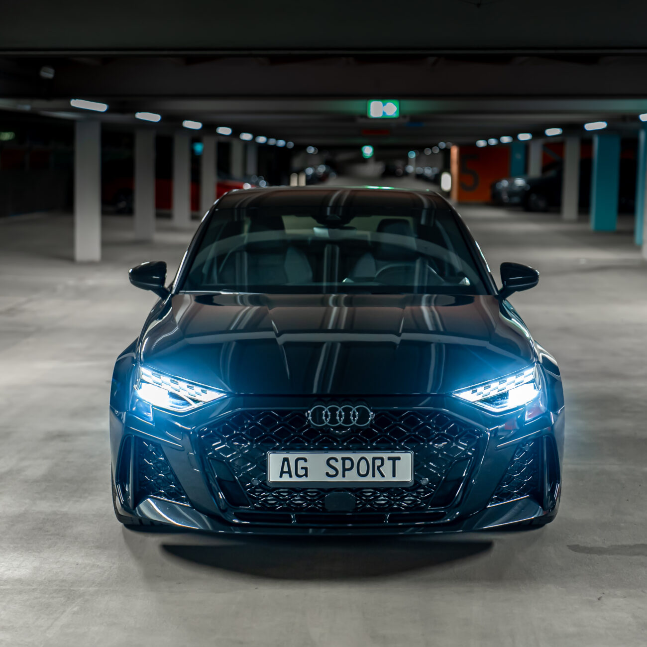 FAQ - Audi RS3 frontalansicht mit den Scheinwerfer an.